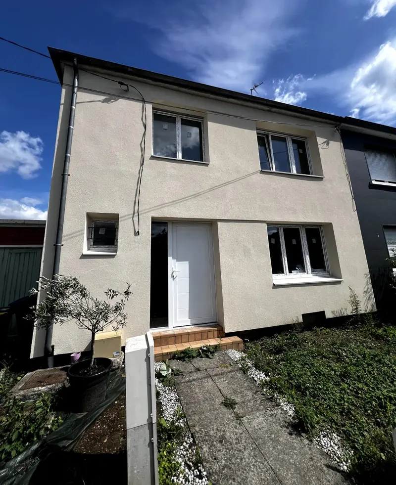 Façade d'une maison mitoyenne après isolation thermique par l'extérieur, enduit clair neuf