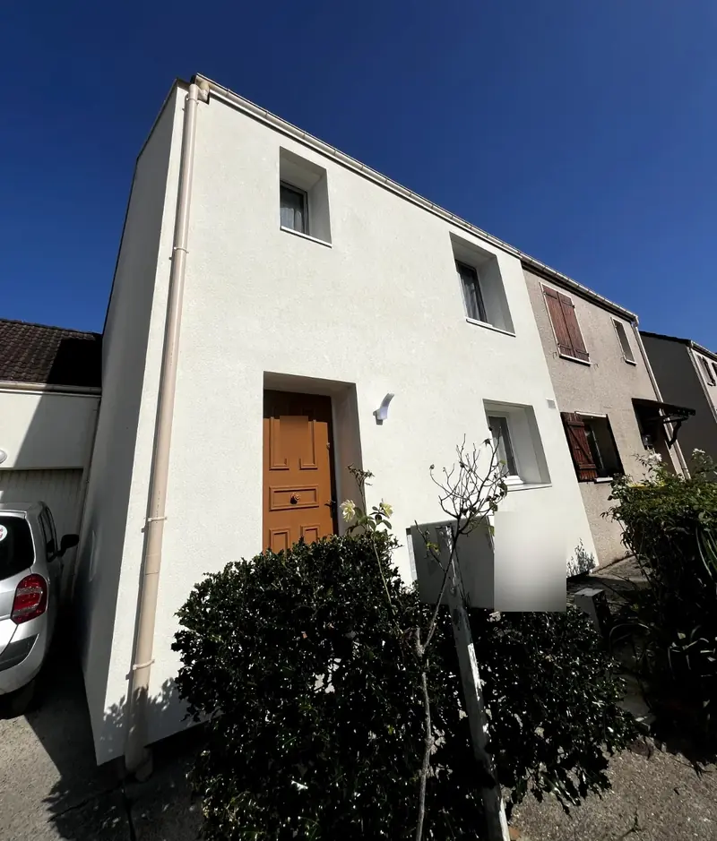 Maison mitoyenne isolée par l'extérieur, façade blanche à côté d'une maison voisine non isolée