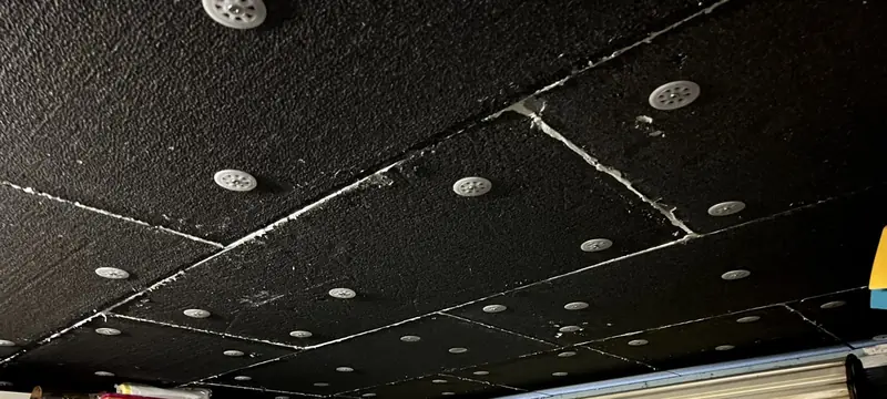 Plafond de garage isolé par panneaux fixés par chevilles rosaces